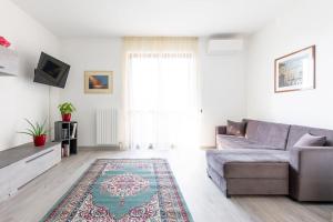 - un salon avec un canapé et un tapis dans l'établissement Oasi 2bedr vicino Groane/Rho Fiera/Milano/MXP, à Cesate