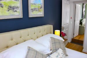 um quarto com uma cama branca e paredes azuis em Elegant 4 bedroom, Maidstone house by Light Living Serviced Accommodation em Maidstone