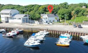 a bunch of boats are docked in a marina at The Old Boathouse at Bunbeg Harbour in Bunbeg