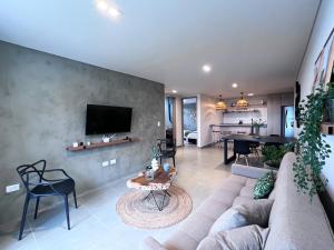 uma sala de estar com um sofá e uma televisão na parede em Parallelo Loft Salento P4 em Salento