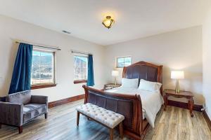 Black Bear Lodge في إيجل: غرفة نوم بسرير وكرسي وأريكة