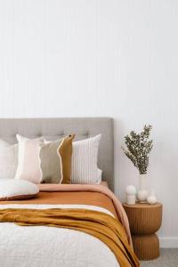 a bedroom with a bed with white walls at Good Soul Cottage in Invermay +8 photos