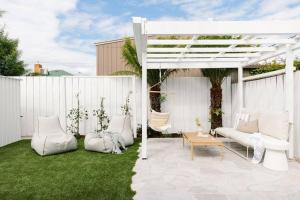 a white pergola with white furniture on a lawn at Good Soul Cottage in Invermay