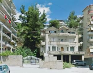 un immeuble d'appartements avec des voitures garées devant lui dans l'établissement Silver Villa, à Gjirokastër