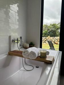 a bathroom with a bath tub with a wooden shelf with towels at Suite romántica panorámica in Alto Boquete