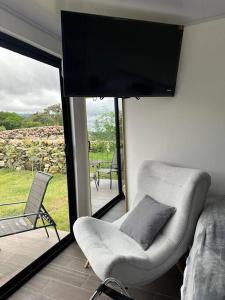 a living room with a couch and a chair and a television at Suite romántica panorámica in Alto Boquete
