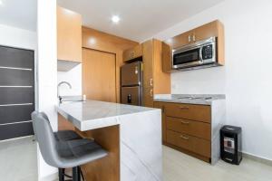 a kitchen with a counter with a sink and a microwave at para relajarse muy cerca de la playa by G P S rentas in Mazatlán