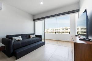 a living room with a black couch and a large window at para relajarse muy cerca de la playa by G P S rentas in Mazatlán