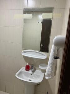 La salle de bains blanche est pourvue d'un lavabo et d'un miroir. dans l'établissement F22R4 Small room attach bath at beach, à Ajman
