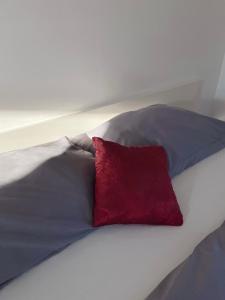 almohada roja en la parte superior de una cama en Hotel Caldor - 24h self-check in, en Münchendorf