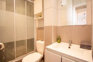 uma casa de banho com um WC, um lavatório e um chuveiro em 2 pièces cocooning (5' RER D Maisons-Alfort) em Alfortville