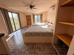 a bedroom with two beds and a ceiling fan at Xbalche eco hotel & RV park 