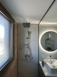 a bathroom with a shower and a sink and a mirror at La Viella in Gastoúni