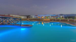 una gran piscina de agua azul con edificios al fondo en Hotel El Cortijo & SPA, en Chefchaouen