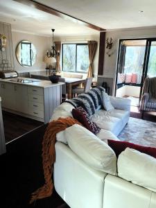 a living room with a white couch and a kitchen at Mountain Retreat Suitable for 2 Families, Sleeps 8 in Mount Buller