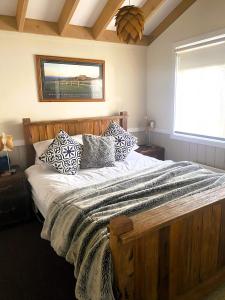 1 dormitorio con cama de madera y almohadas en Mountain Retreat Suitable for 2 Families, Sleeps 8, en Mount Buller