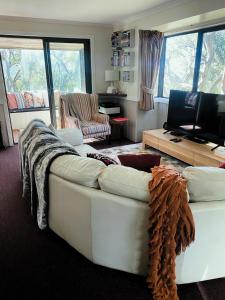sala de estar con sofá blanco y TV en Mountain Retreat Suitable for 2 Families, Sleeps 8, en Mount Buller