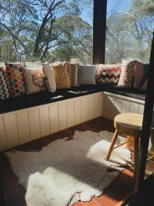 a window sill with pillows and a stool in a room at Mountain Retreat Suitable for 2 Families, Sleeps 8 in Mount Buller