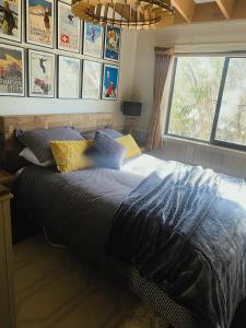 a bedroom with a bed with a blue blanket and a window at Mountain Retreat Suitable for 2 Families, Sleeps 8 in Mount Buller