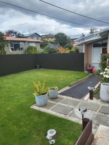 a backyard with a fence and a grass yard at BARNES STREET BNB in Timaru