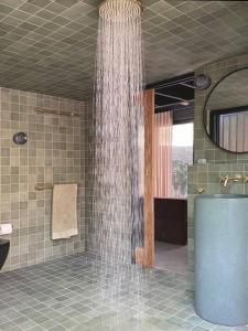a shower in a bathroom with water coming out of it at The Base at Byron in Suffolk Park