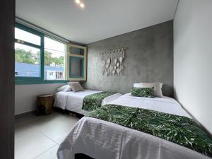 a bedroom with two beds and a window at Parallelo Loft Salento P4 in Salento