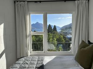 a bedroom with a large window with a view at Wee Dram in Queenstown