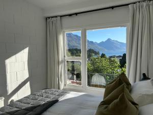 a bedroom with a bed and a large window at Wee Dram in Queenstown
