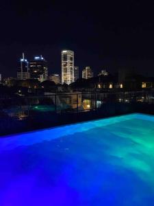 una piscina blu con vista sullo skyline della città di notte di More Echevarriarza apartamento de estreno!! a Montevideo
