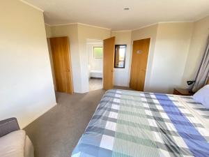 a bedroom with a bed and a bath room at Pohara's Kauri Lodge in Pohara +17 photos