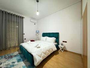 - une chambre avec un grand lit et une tête de lit verte dans l'établissement Silver Villa, à Gjirokastër