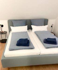 a large bed with two blue pillows on it at #wärmespenden - Naturnahe Unterkunft in der Burgenstadt Schlitz in Schlitz