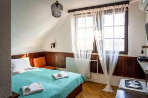 a bedroom with a bed with two towels on it at Castle Residence Balaton in Balatonföldvár