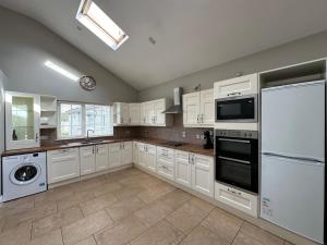 a kitchen with white cabinets and a white refrigerator at Dublin Airport Homestay in Dublin