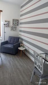 a living room with a blue couch and striped wall at Turin Little House in Turin