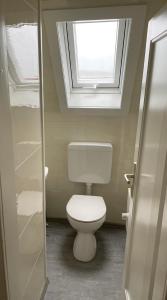 a bathroom with a white toilet with a window at #wärmespenden - Naturnahe Unterkunft in der Burgenstadt Schlitz in Schlitz