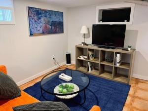 a living room with a table and a television at Charming North End Studio #2 in Halifax