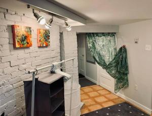 un couloir avec un mur en briques blanches et une porte dans l'établissement Charming North End Studio #2, à Halifax