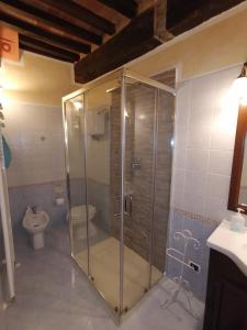 uma cabina de duche em vidro numa casa de banho com WC em Casa degli Angeli em Torrita di Siena