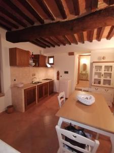 uma cozinha com mesa e cadeiras num quarto em Casa degli Angeli em Torrita di Siena