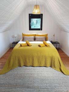 1 dormitorio con 1 cama amarilla con manta amarilla en Gîte de charme L' Écrin Vert Aveyron, en Anglars-Saint-Félix