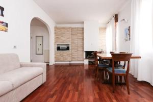 Modena Visit Apartment في مودينا: غرفة معيشة مع أريكة بيضاء وطاولة