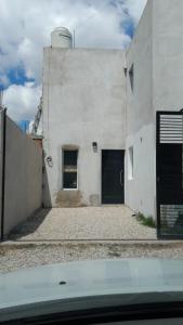 un edificio bianco con una porta e un garage di Casa Esther La Plata 1538 a Melchor Romero