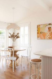 a white dining room with a table and chairs at Soul Sister Cottage in Invermay