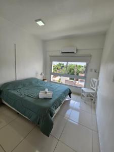 a bedroom with a green bed and a window at YSYRY PISO 4, BONITO Y MODERNO DEPTO. EN BARRIO VILLA SARITA in Posadas