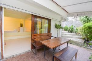 une table en bois et un banc sur une terrasse couverte dans l'établissement Babosam Apartments, à Boracay