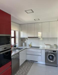 een keuken met witte kasten en een wasmachine bij Apartament Praceta Vila do Conde in Vila do Conde