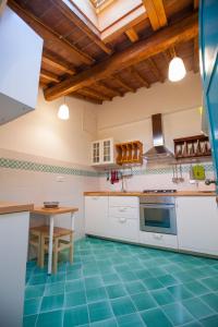 eine Küche mit weißen Schränken und einem Tisch in der Unterkunft Appartamento Montebello in Florenz