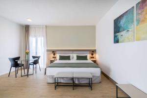 a bedroom with a bed and a table and chairs at Occidental Puerto Banús in Marbella
