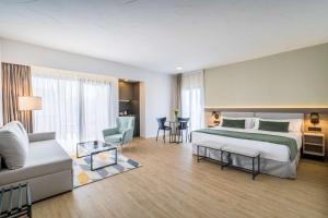 a hotel room with a bed and a couch at Occidental Puerto Banús in Marbella